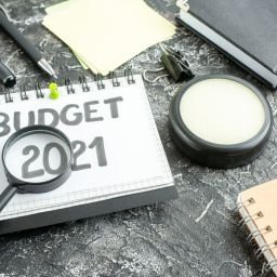 above view budget note with magnifier on dark background color college student school job bank money business work